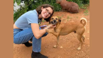 Cachorro caramelo cativa com seu lindo sorriso espontâneo em foto com universitária